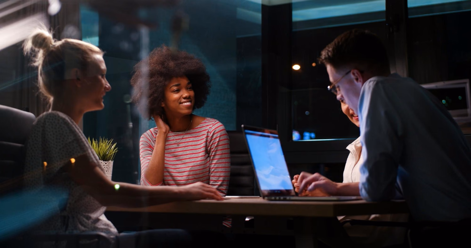 Three colleagues talking things over at a laptop